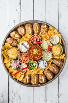 a platter filled with different types of food on top of a white wooden table