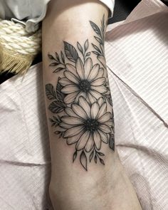 a black and white flower tattoo on the arm