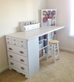 a white desk with several drawers and stools