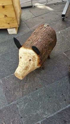 an animal made out of wood sitting on the ground