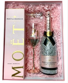 a bottle of champagne and a wine glass in a pink box with the word mott & chandon written on it