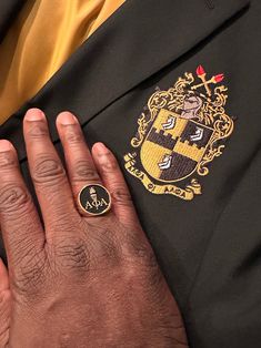 a close up of a person's hand with a ring on their lapel