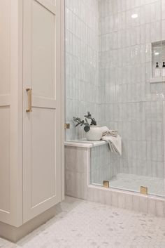 a bathroom with white tile walls and floor