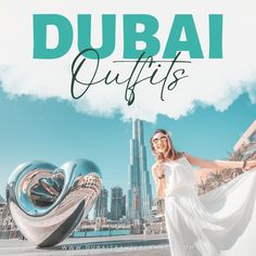 a woman standing in front of a giant sculpture with the words dubai outfits on it