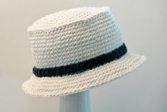 a white crocheted hat is on a mannequin