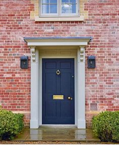 a black door is on the side of a brick building