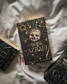 three books laying on top of a bed next to each other