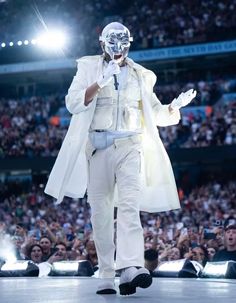 a man in white is walking down the runway