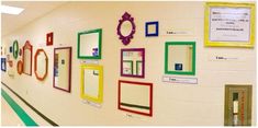 there are many frames on the wall in this school hallway that have been decorated with different colors and shapes