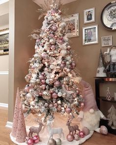 a white christmas tree with pink and silver ornaments