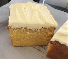 a piece of cake with white frosting sitting on top of a paper wrapper