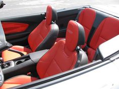 the interior of a sports car with red and black seats