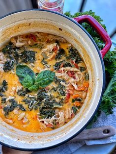 a pot filled with chicken, spinach and cheese