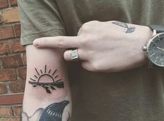 a person with a tattoo on their arm holding onto the wrist of another person who is wearing a watch