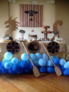 a table topped with blue and white balloons