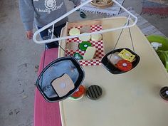 a young boy standing in front of a table with food on it and an object hanging from the ceiling