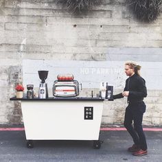 a man standing next to a table with coffee on it and an appliance