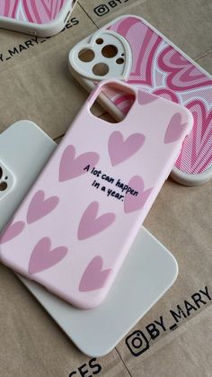 two cell phones sitting on top of each other next to one another with hearts painted on them