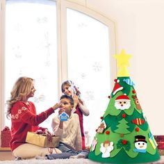 three children are sitting around a christmas tree