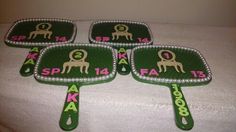 four green trays with designs on them sitting on a white tablecloth covered surface