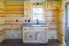 a kitchen with wooden walls and cabinets in it