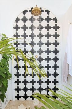 a white door with black crosses painted on it and a potted plant next to it