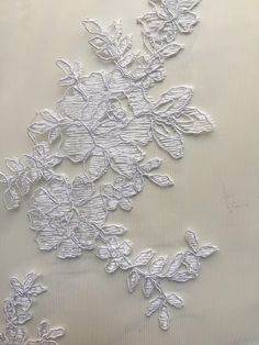 an embroidered fabric with white flowers on it