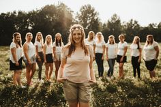 a group of women standing on top of a lush green field next to each other