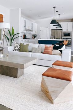 a living room filled with white furniture and lots of pillows on top of it's couches