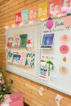 a bulletin board with many different things on it next to a christmas tree and presents