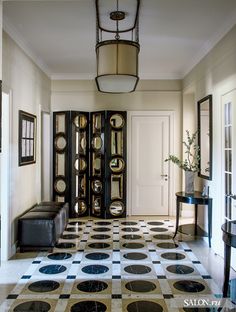 the hallway is decorated in black and white with polka dots on the floor, as well as a chandelier