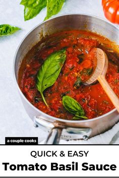 a pot full of tomato sauce and basil leaves with a wooden spoon in the pan