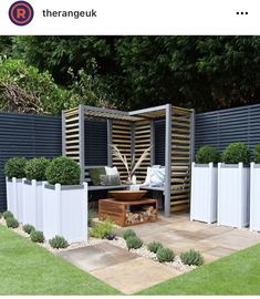 an outdoor seating area with wooden slats and white picket fenced in areas around it