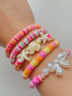 the bracelets are decorated with different colored beads and bows on each one arm,