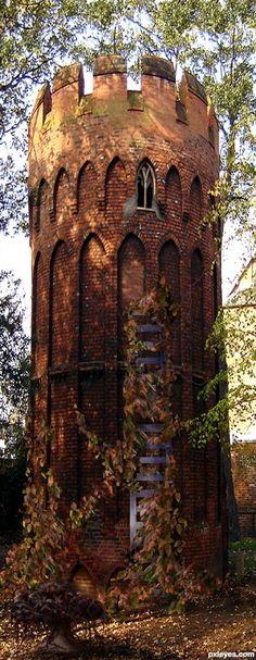 an old brick tower with trees in the background