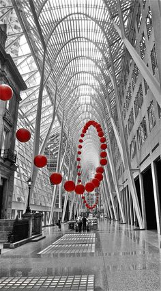 the inside of a large building with many red objects hanging from it's ceiling