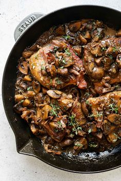 a skillet filled with chicken and mushrooms