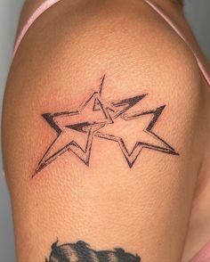 a woman's arm with a star tattoo on the back of her left shoulder