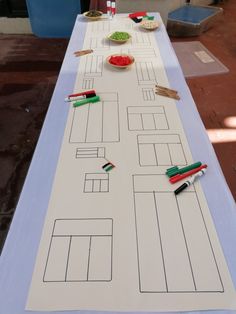 a long table with paper cut out to look like a map and markers on it