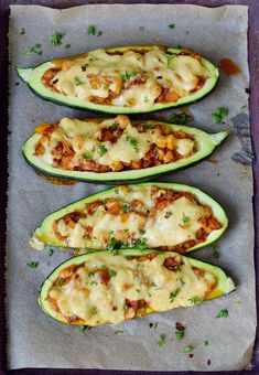 three stuffed zucchini boats with meat and cheese in them on a baking sheet