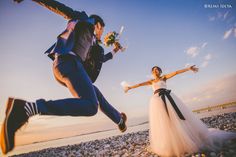 a bride and groom jumping in the air