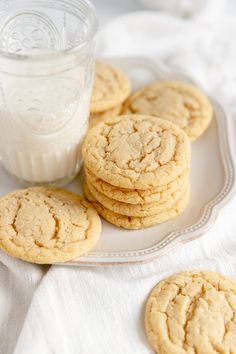 several cookies on a plate next to a glass of milk