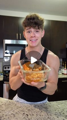 a young man is holding a bowl of food