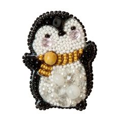 a beaded penguin brooch sitting on top of a white surface