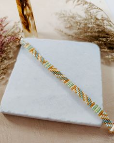 This artisan-crafted bead loom bracelet features an attractive Southwestern-inspired Japanese Miyuki glass seed bead design, giving a trendy boho aesthetic complemented by a lovely bee charm. Handcrafted with precision, each piece of bohemian jewelry showcases a unique blend of vibrant multicolor beads, accented by 18k gold plating and an adjustable gold-filled lobster claw clasp. Update your accessory collection with this handmade beaded bracelet that not only looks stylish but also supports our vital bee conservation efforts. We donate a portion of this sale to HoneyLove, a non-profit in California USA dedicated to saving the bees. Celebrate your individuality and contribute to an important cause with your purchase--get this one-of-a-kind piece today before it's gone! This bracelet is ad Artisan Beaded Bracelets With Tiny Beads, Artisan Beaded Bracelets With Colorful Heishi Beads, Artisan Beaded Bracelet With Tiny Beads, Adjustable Handwoven Heishi Beads Jewelry, Southwestern Beaded Friendship Bracelets As Gifts, Southwestern Style Beaded Bracelets With Tiny Beads As Gift, Southwestern Style Colorful Beads Friendship Bracelets As Gift, Artisan Beaded Bracelets For Jewelry Making, Yellow Beaded Bohemian Bracelets