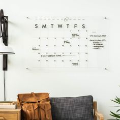 a black and white photo of a couch with a calendar on the wall behind it