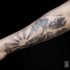 a person with a tattoo on their arm that has an image of the great wave