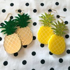 three pineapples are sitting next to each other on a polka dot tablecloth