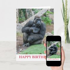 a person holding up a card with a gorilla on it and an iphone next to it