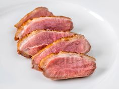 three pieces of meat sitting on top of a white plate